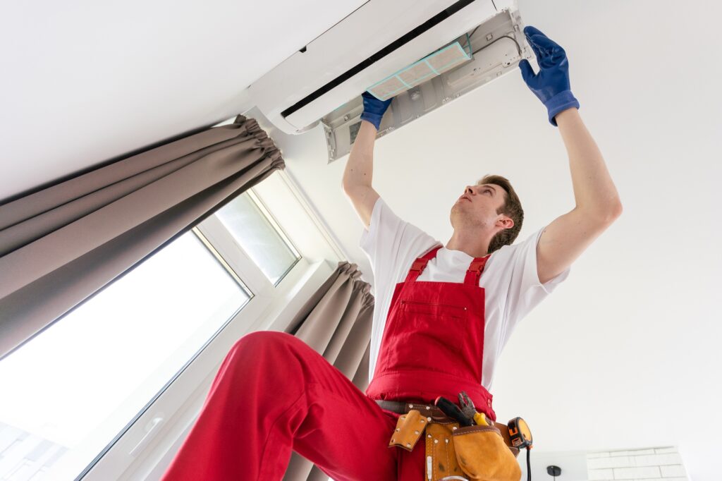 Service man is cleaning, repair and maintenance of air conditioner