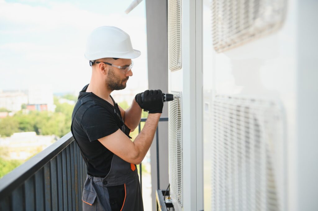 technician working on air conditioning or heat pump outdoor unit.