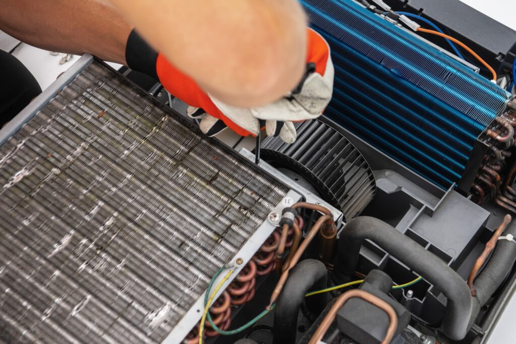 Technician Working on RV Recreational Vehicle AC Unit With Screwdriver