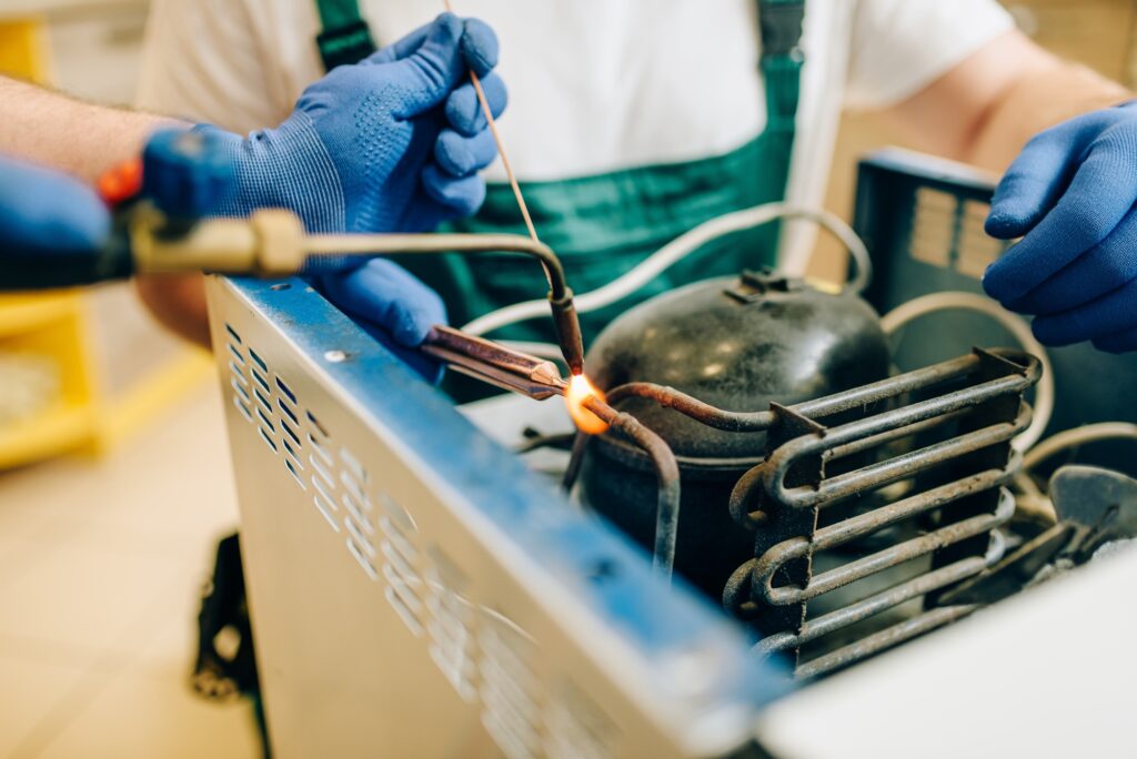 Worker with burner repairs cooling system